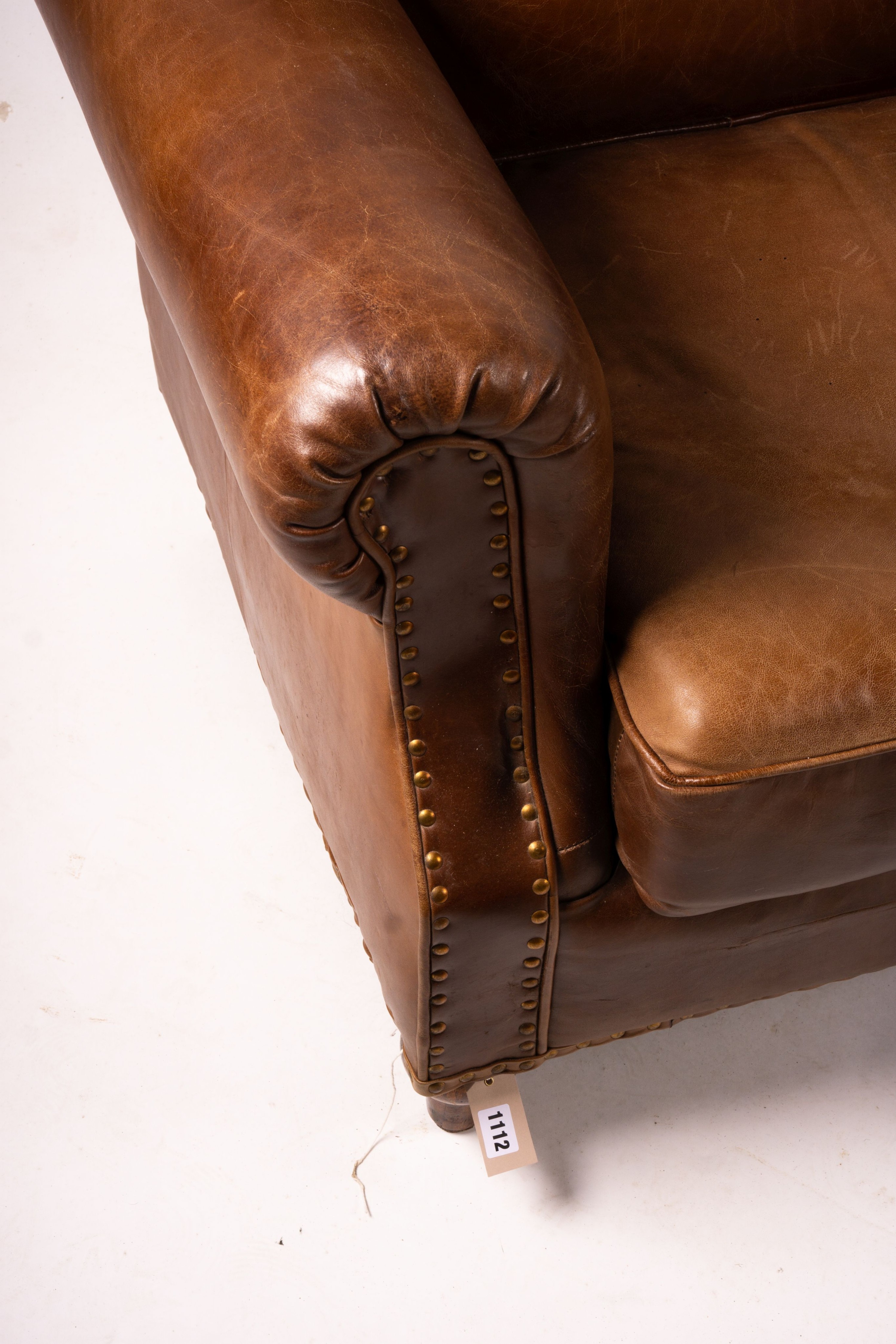 A pair of brown leather club armchairs, width 96cm, depth 80cm, height 90cm